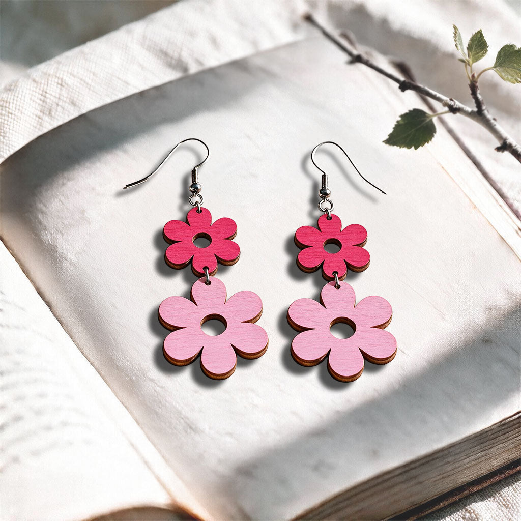Raspberry and mauve Double Retro plywood earrings made in Finland, photographed on a vintage book in natural sunlight