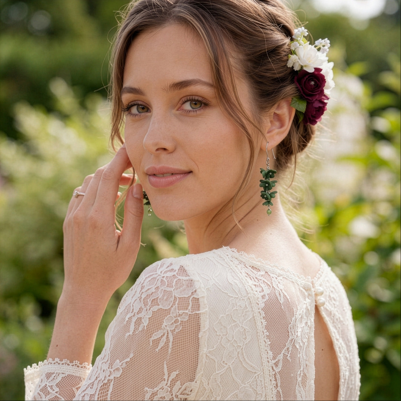 Woman wearing Shadow Vine Green Earrings in a soft summer garden. Handmade floral earrings inspired by the calm strength and quiet beauty of the forest.