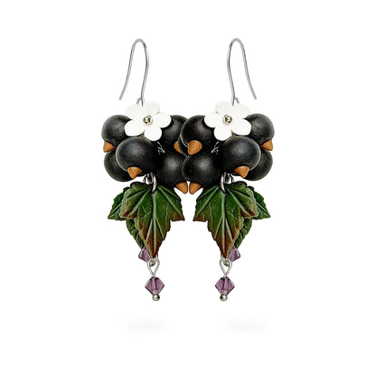 Shadow Currant Earrings featuring hand-shaped blackcurrants, green leaves, white flowers, and purple crystal details. Handmade in Finland by byMinta.