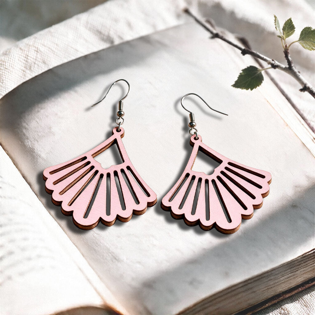 Babypink Fan plywood earrings made in Finland, photographed on a vintage book in natural sunlightYellow Fan plywood earrings made in Finland, photographed on a vintage book in natural sunlight